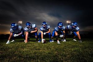 A high school football offensive line crouched