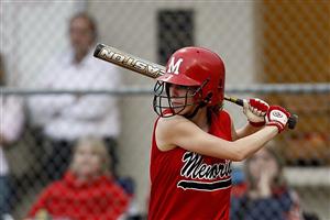 Softball player wearing a batting helmet and preparing to swing her bat.